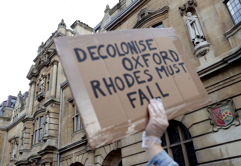 A demonstrator is seen with a placard during a protest for the removal of a statue of British imperialist Cecil Rhodes on the outside of Oriel College in Oxford, following the death of George Floyd who died in police custody in Minneapolis, Oxford, Britain, on 9 June 2020