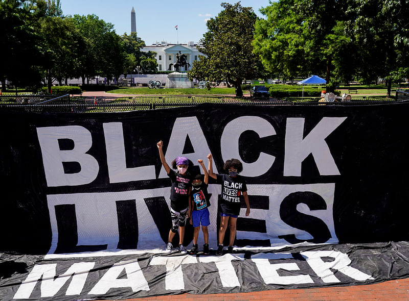 A group of children hold up their fists in front of a Black Lives Matter sign as people gather to protest the death in Minneapolis police custody of George Floyd, near the White House in Washington, US, 7 June 2020.