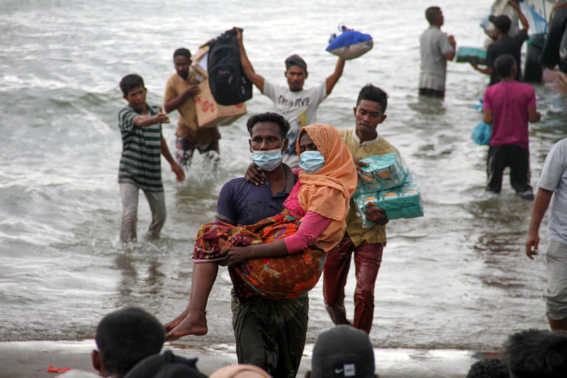 Rohingya refugees are evacuated by locals at a coast of North Aceh, Indonesia, 25 June 2020 in this photo taken by Antara Foto.