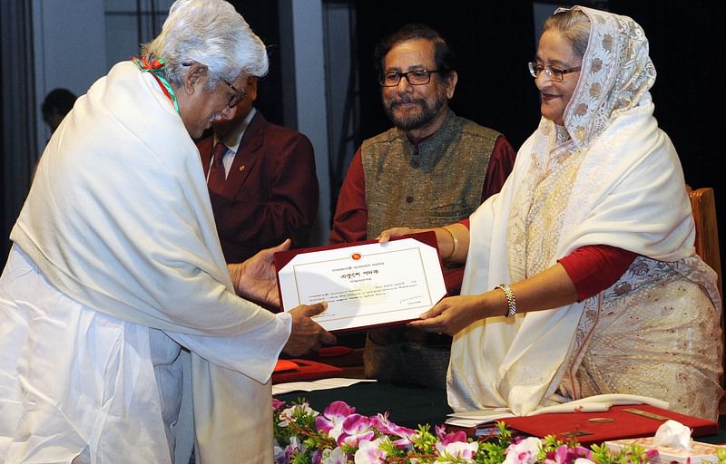 Prime minister Sheikh Hasina hands over the Ekushey Padak to Kamal Lohani as cultural affairs minister Asaduzzaman Noor looks on at Osmani Memorial Auditorium, Dhaka on 19 February 2015