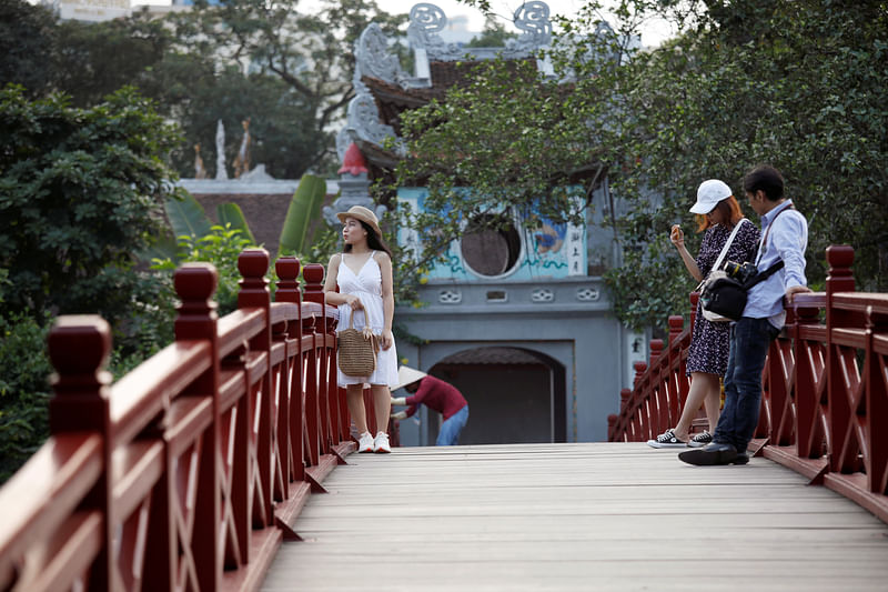 Vietnamese tourists pose for photos on the The Huc bridge at Hoan Kiem lake after the Vietnamese government eased the lockdown following the coronavirus disease (COVID-19) outbreak, in Hanoi, Vietnam 18 May.