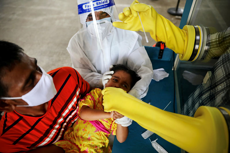 A health worker collects a swab sample from a child at Mugda Medical College and Hospital, as the coronavirus disease (COVID-19) outbreak continues, in Dhaka, Bangladesh, on 23 June 2020