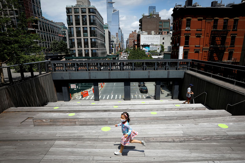 A child wearing a protective face mask plays on a sitting platform painted with social distancing circles on the elevated High Line Park in Manhattan on the first day of the park's re-opening following the outbreak of the COVID-19 in New York City, New York, US, on 16 July 2020