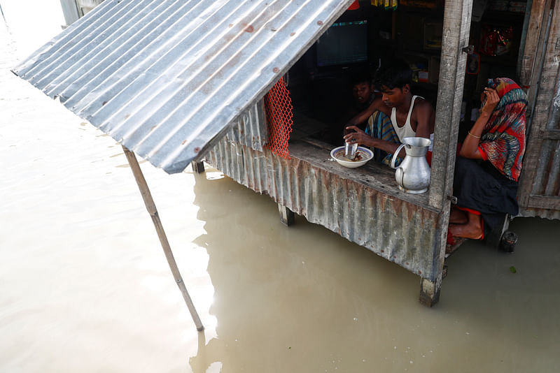 Surrounded by floods, a man has a meal in his small shop in Jamalpur, Bangladesh, 18 July 2020.