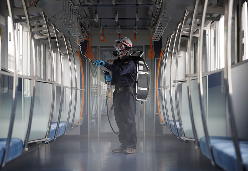 An employee of the Tokyo Metro wearing a protective mask and goggles sprays chemicals for anti-virus and bacteria coating in order to prevent infections following the coronavirus disease (COVID-19) outbreak, inside a railway train at the Tokyo Metro's rail-yard in Tokyo, Japan on 9 July 2020