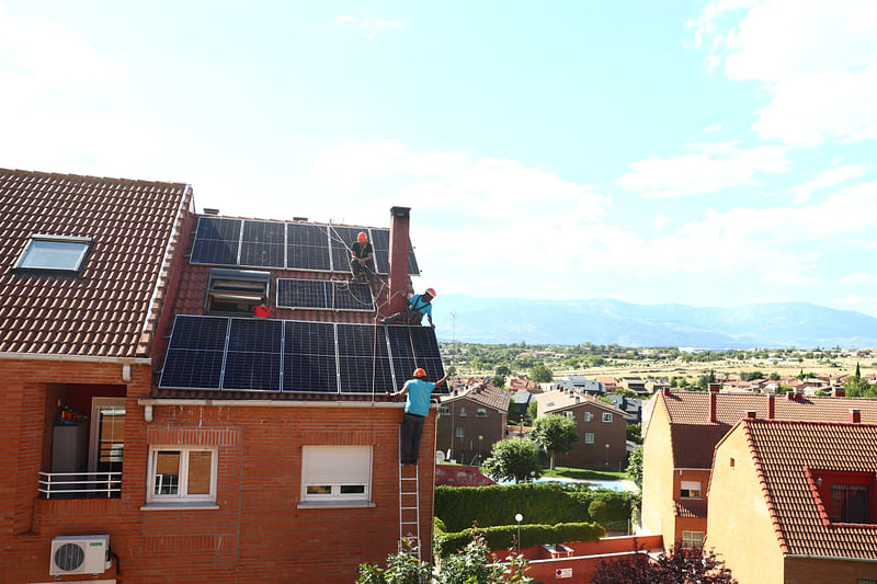 Rodrigue Kauahou, Jose Carlos Navarro and David Pascual, workers of the installation company Alromar, set up solar panels on the roof of a home in Colmenar Viejo, Spain on 19 June 2020