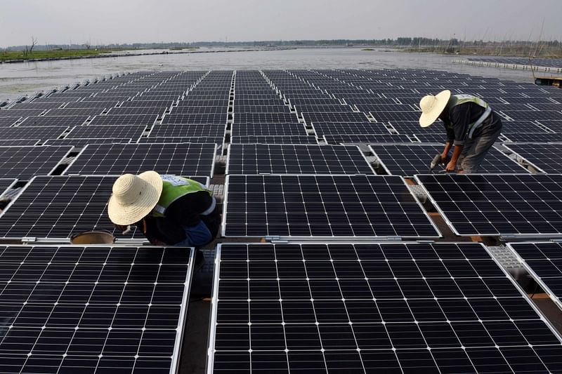 Workers at a floating solar power plant in a lake in Huainan, in China’s central Anhui province.