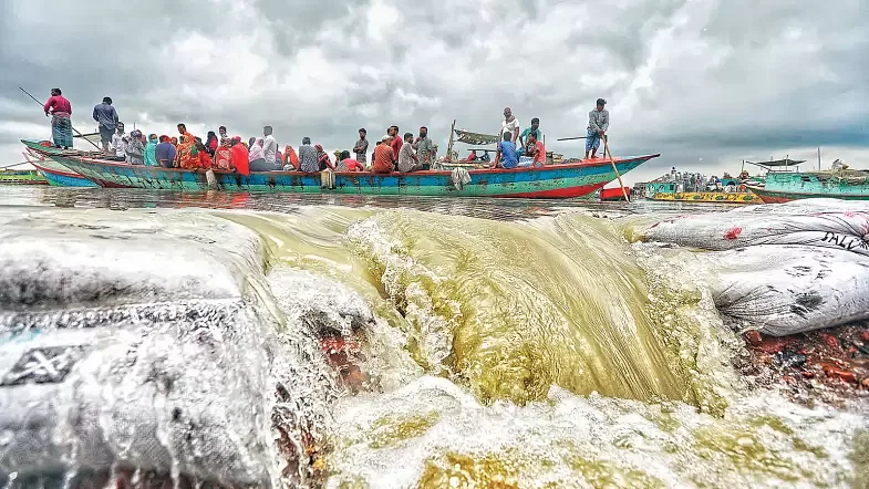 File photo. People ride a boat as water of river Padma floods a road in Dakkhin Medinimandal in Louhajang, Munshiganj amid worsening flood situation in the country on 23 July 2020