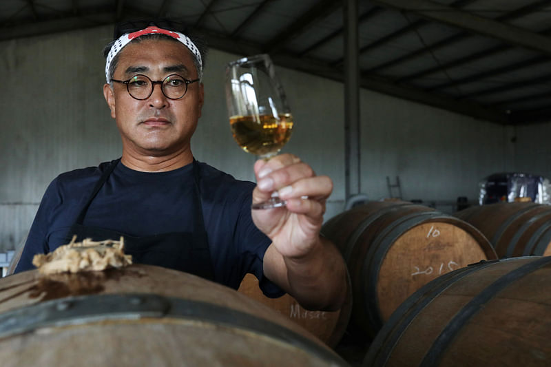 Chen Chien-hao, 52, holds a glass of his wine at Shu Sheng Leisure Domaine in Taichung, Taiwan, 20 July 2020.