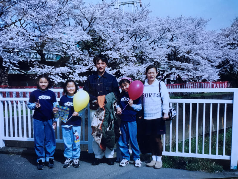 Kieko Uchida poses for a photograph with her husband and daughters against the backdrop of cherry blossoms in full bloom at Toshimaen amusement park in Tokyo, Japan, in this handout photo taken 8 April 2000 and released by Kieko Uchida, obtained by Reuters on 29 August 2020.