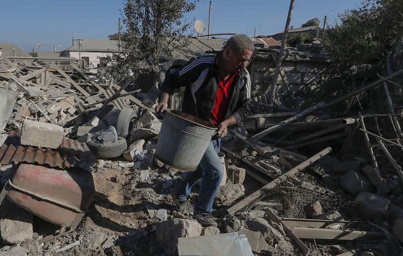 A man removes the debris of a building following recent shelling during a military conflict over the breakaway region of Nagorno-Karabakh, in Stepanakert 17 October 2020.