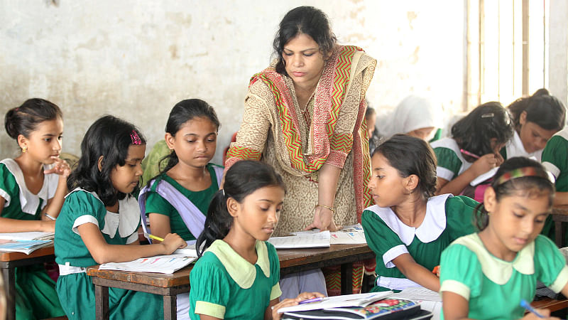 Photo shows a teacher taking a class at a primary school.