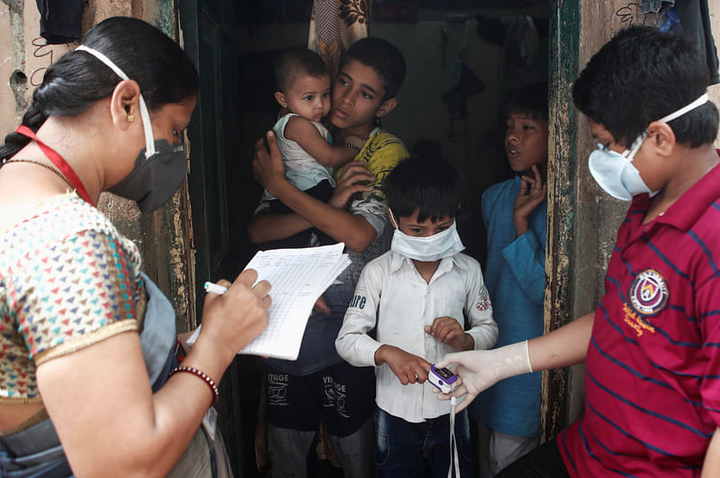 Community health volunteers check the pulse of a resident during a check-up campaign for the coronavirus disease (COVID-19) in Mumbai, India, 3 October 2020.