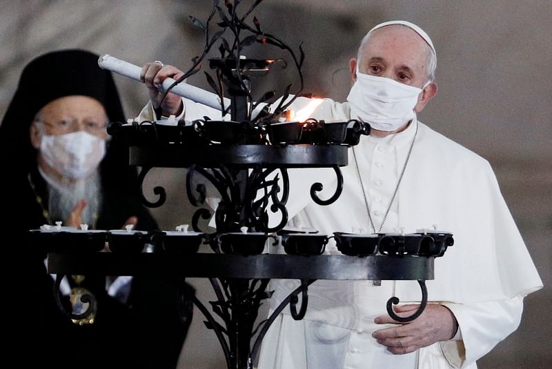 Pope Francis wearing a face mask lights a candle during a ceremony for peace with representatives from various religions in Campidoglio Square, in Rome, Italy, on 20 October 2020