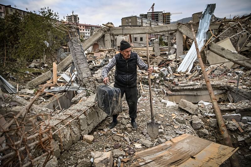 Retired police officer Genadiy Avanesyan, 73, searches for belongings in the remains of his house, which is said was destroyed by Azeri shelling, in the city of Stepanakert on 10 October.