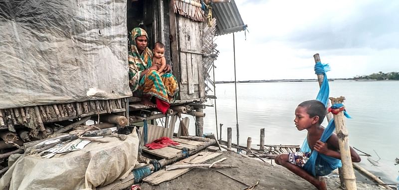 A family dwelling on an embankment as river erosion destroys their home following the damage of a coastal embankment along the Bay in Satkhira. Kurikahnia, Ashashuni upazila, Satkhira on 28 September 2020