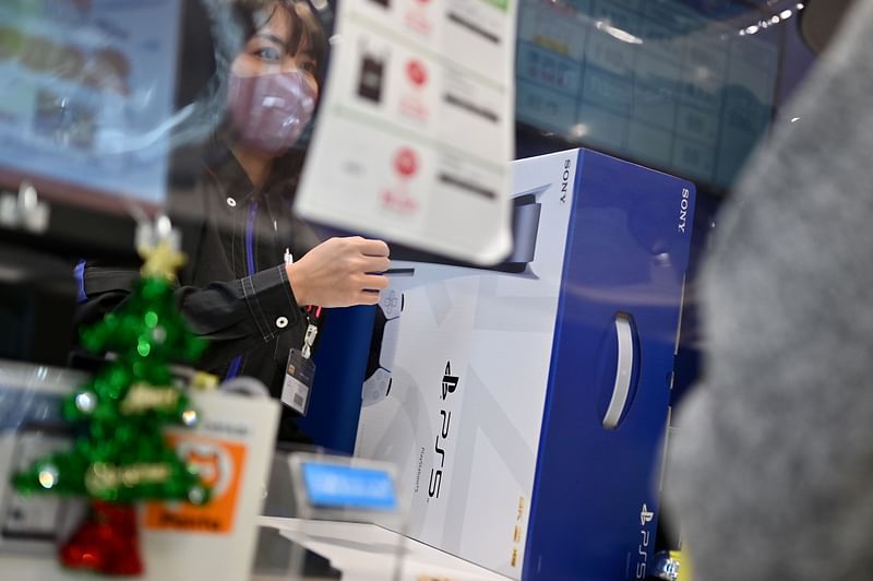 A customer buys the new Sony PlayStation 5 gaming console on the first day of its launch, at an electronics shop in Kawasaki, Kanagawa prefecture on 12 November