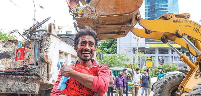 Rickshaw puller Fazlur Rahman cries as his battery-run rickshaw was destroyed during the eviction drives by Dhaka city corporation