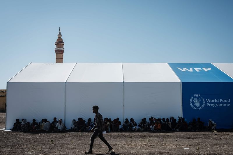 Ethiopian refugees who fled the Tigray conflict rest in the shadow of a warehouse erected by the World Food Programme (WFP) at Village Eight transit centre near the Ethiopian border in Gedaref, eastern Sudan, on 2 December 2020.