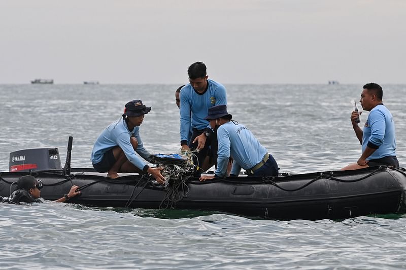 Indonesian Navy divers gather wreckage from Sriwijaya Air flight SJY182 during a search and rescue operation at sea near Lancang island on 10 January