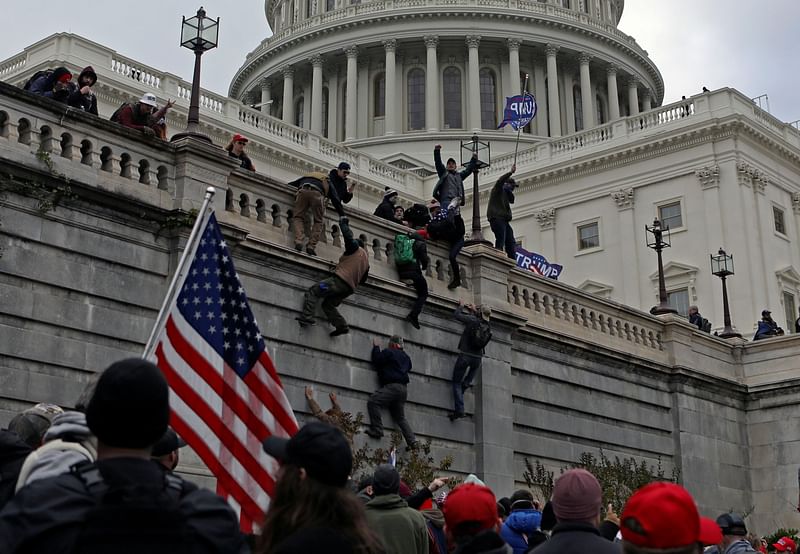 Supporters of US president Donald Trump climb a wall during a protest against the certification of the 2020 presidential election results by the Congress, at the Capitol in Washington, US, on 6 January 2021