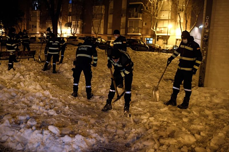 Members of the Spanish Military Emergencies Unit (UME) remove snow outside the General Fanjul Health Centre in Madrid early on 13 January