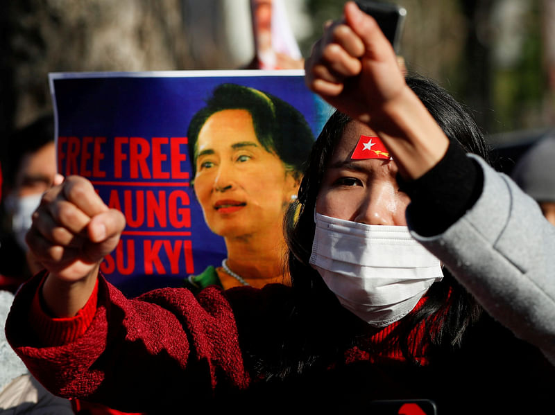 Protesters from Myanmar residing in Japan raise their fists and hold a poster depicting Aung San Suu Kyi during a rally against Myanmar's military, after it seized power from a democratically elected civilian government and arrested Suu Kyi, outside Foreign Ministry in Tokyo, Japan on 3 February 2021