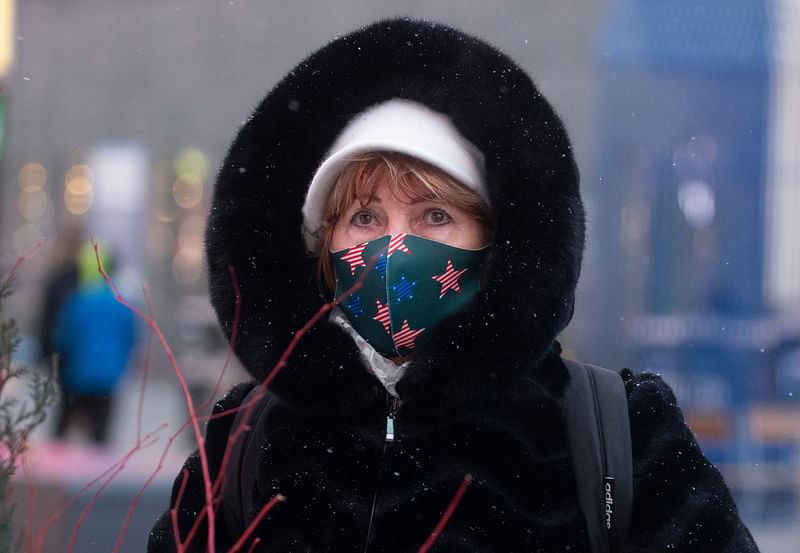 A woman visits Times Square as snow falls during a winter storm in New York on 31 January