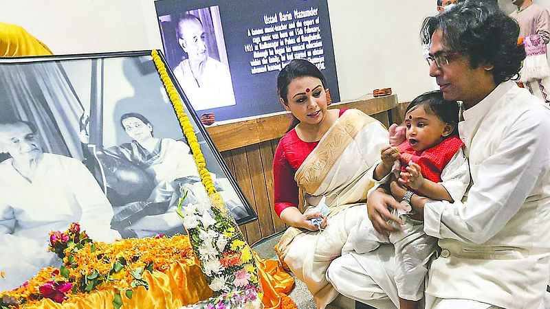 Bappa Mazumder along with his daughter Agni Mitra and wife Tania places wreaths at the portrait of his father.