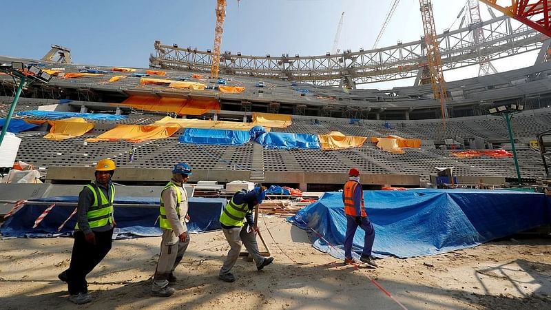 Migrant workers work at a construction site in Qatar