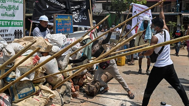 Protesters reinforce a barricade during a crackdown by security forces on demonstrations against the military coup in Yangon on 20 March 2021