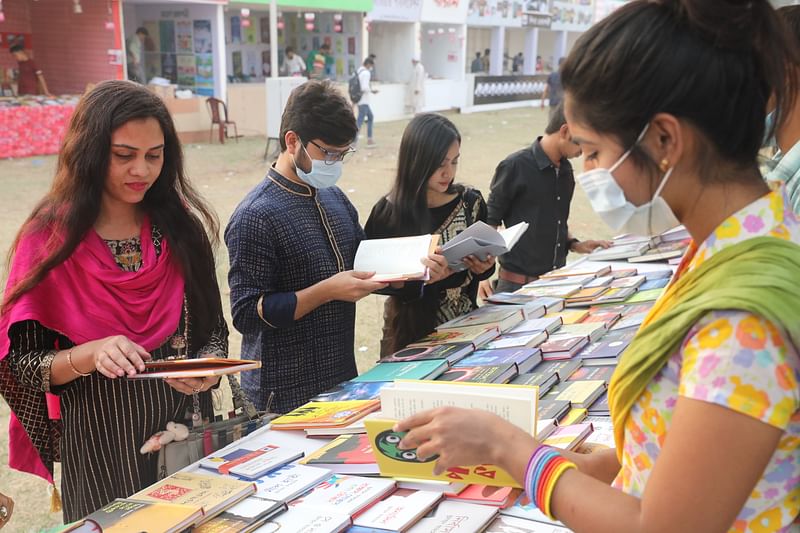 Visitors browsing books at a stall at Suhrawardy Udyan portion of the month-long Amar Ekushey Book Fair-2021 on the first day on 18 March 2021.