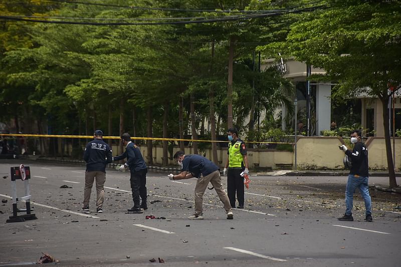 Indonesian forensic police examine the site after a suspected bomb exploded near a church in Makassar on 28 March