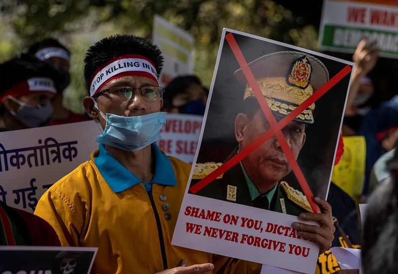 A Myanmar citizen living in India holds a poster of Myanmar's army chief Senior General Min Aung Hlaing with his face crossed out during a protest, organised by Chin Refugee Committee, against the military coup in Myanmar, in New Delhi, India, on 3 March 2021