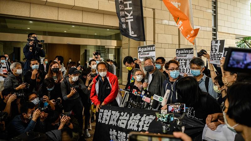 Pro-democracy activist Lee Cheuk-yan (C) arrives at West Kowloon court in Hong Kong on 16 April 2021, to receive sentencing after being found guilty of organising an unauthorised assembly on 18 August 2019