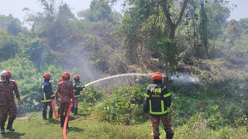 Fire fighters work to douse the blaze at Lawachhara reserve forest in Kamalganj, Moulvibazar on 24 April 2021