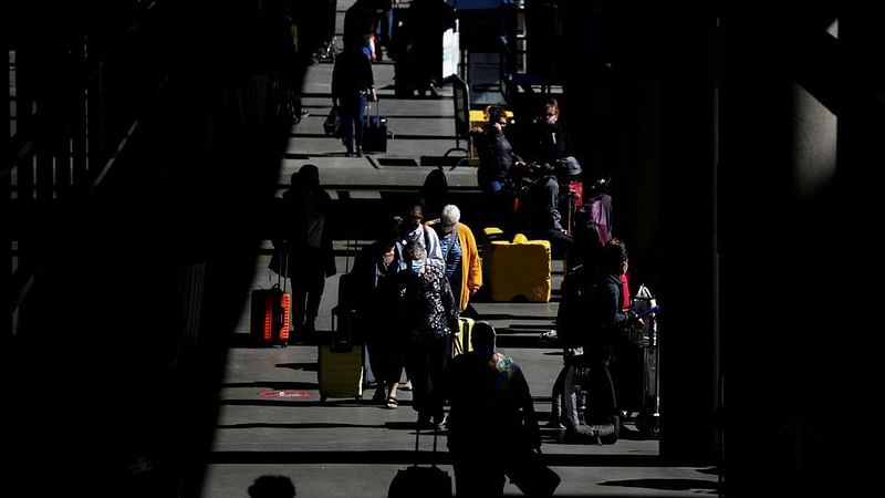 Travelers walk through a pick-up area in the arrivals section at Seattle-Tacoma International Airport in SeaTac, Washington, U.S. 12 April 2021.