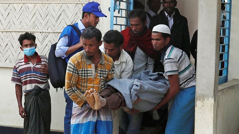 Rohingya people take an injured to a local health centre