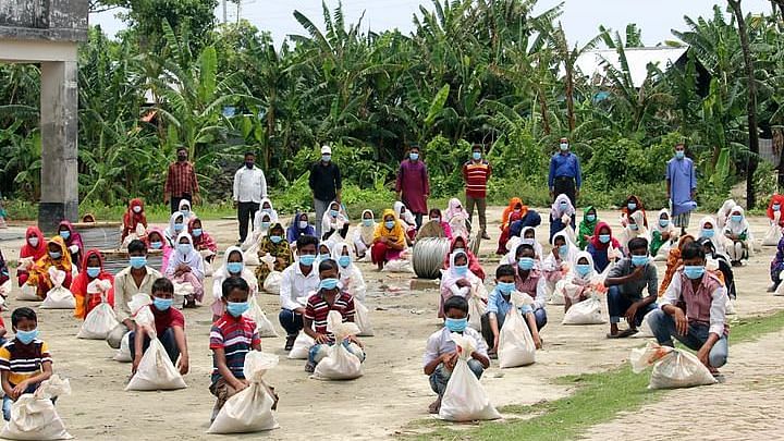 Students receive gift packets at the Madanpur Alor Pathshala premises.