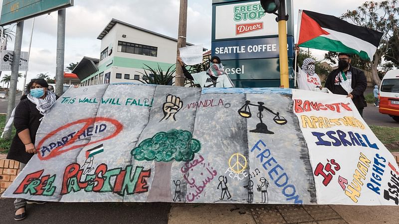 Pro-Palestinian supporters hold banners and flags during a protest to condemn the ongoing Israeli air strikes on Gaza, in Durban on 18 May 2021