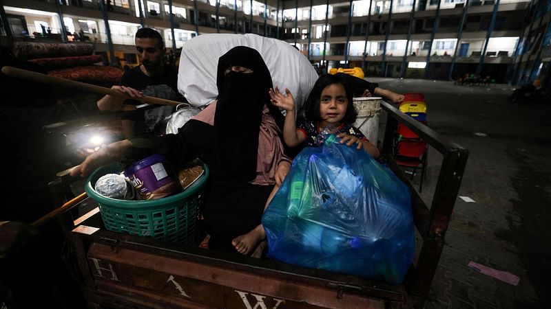 A family that was sheltering at a United Nations run school, return with their belongings to their home following the ceasefire brokered by Egypt between Israel and the ruling Islamist movement Hamas in the Gaza Strip, on 21 May 2021 in Gaza City