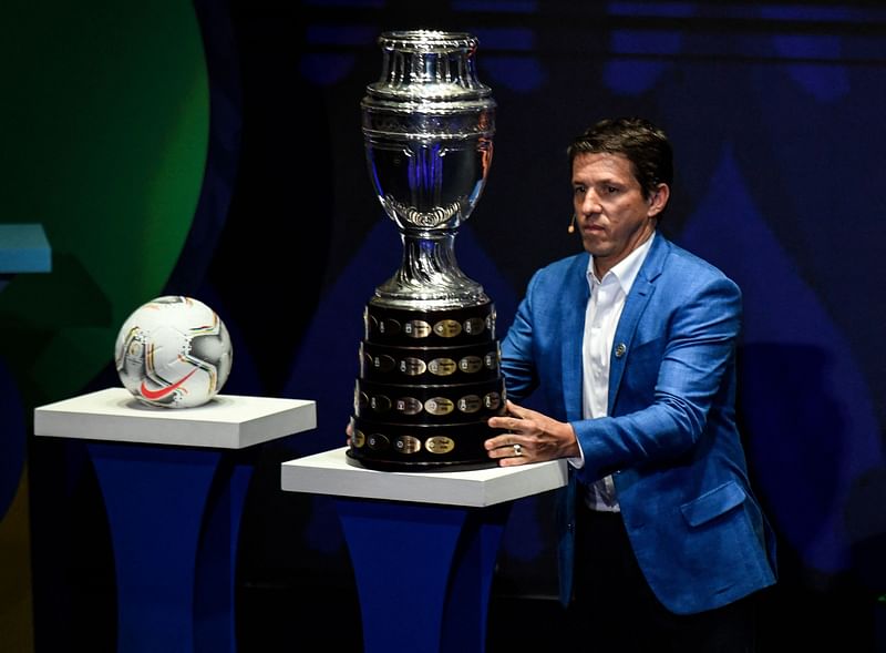 n this file photo taken on 3 December, 2019 Brazilian former footballer Juninho Paulista presents the Copa America trophy on the stage during the draw of the Copa America 2020 football tournament at the Convention Centre in Cartagena, Colombia