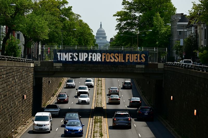 On 28 April, 2021, a banner reading "Time's up for fossil fuels" hangs from a bridge in front of the U.S. Capitol.