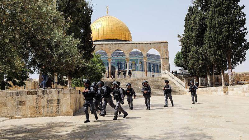 Israeli security forces run during clashes with Palestinians at the compound that houses Al-Aqsa Mosque, known to Muslims as Noble Sanctuary and to Jews as Temple Mount, in Jerusalem's Old City on 21 May 2021