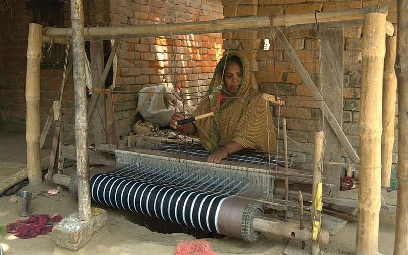 A woman waves a handloom.