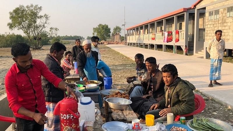 Rohingya people chat at an open-air tea stall in Bhasan Char on 30 December 2020