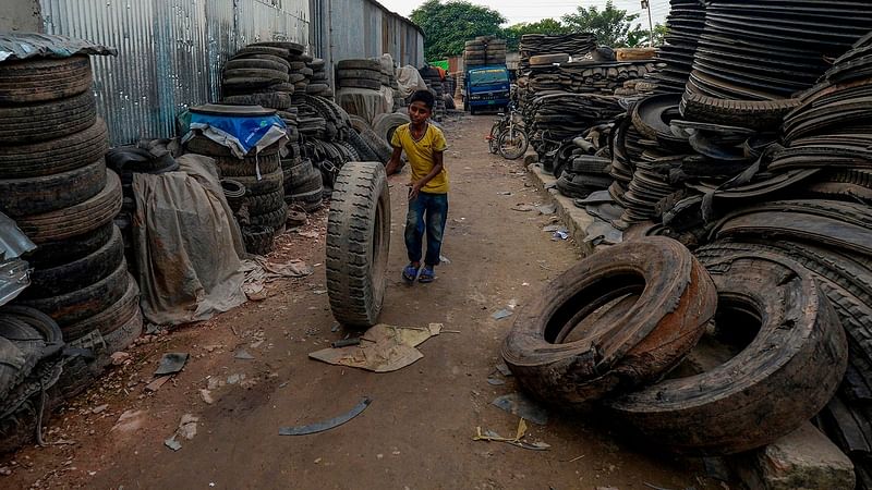 A child labourer handles an old tyre in Dhaka on 1 September 2019