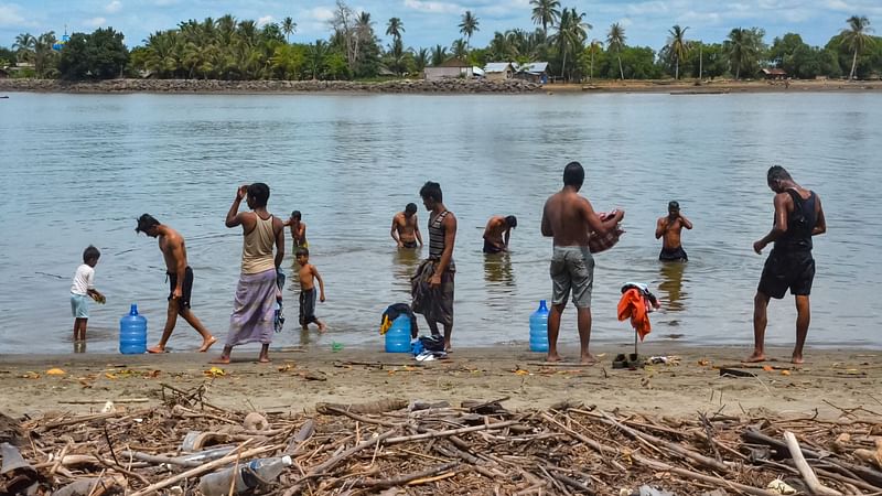 Rohingya refugees bathe at a beach in Pulau Idaman, a small island off the coast of East Aceh in northern Sumatra on 5 June 2021, a day after about 80 Rohingya landed their vessel off the Indonesian coast