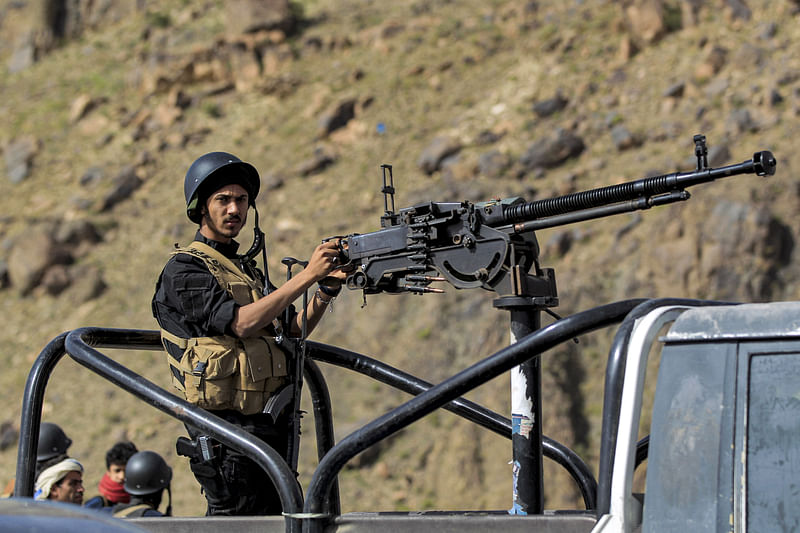 A member of security forces loyal to Yemen's Huthi rebels mans a turret in a technical vehicle (pickup truck with a mounted turret) while on guard near a bonfire incinerating seized narcotic substances, in the Huthi-held capital on 26 June 2021, the United Nations' designated "International Day Against Drug Abuse and Illicit Trafficking"