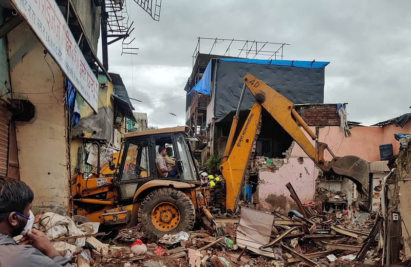 Rescue workers search for survivors in the debris after a residential building collapsed in Mumbai, India, on 10 June 2021